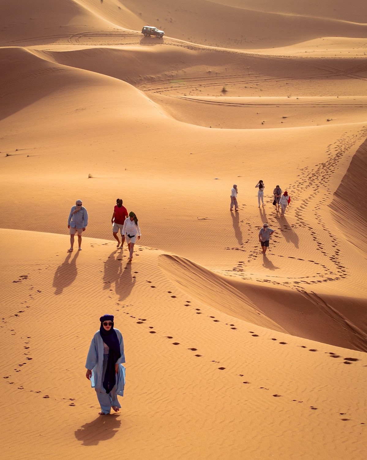 Walkers exploring the Sahara dunes of Merzouga led by a local Berber guide