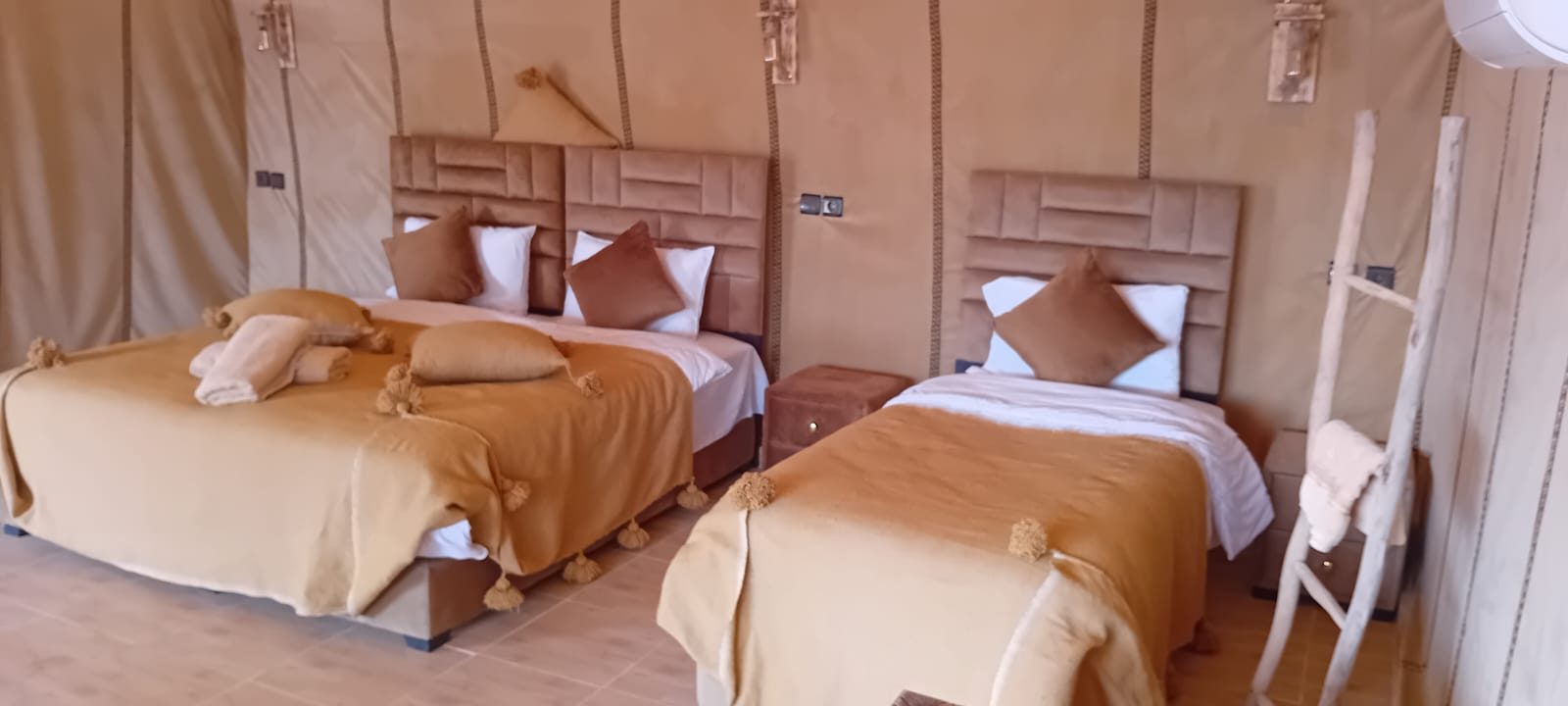 Grand Dune Luxury Camp glowing with warm lights after sunset, a small camp in the wide Erg Chebbi desert night