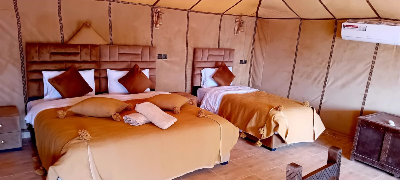 Private luxury tents of Grand Dune Luxury Camp glowing at dusk among the Erg Chebbi dunes of Merzouga