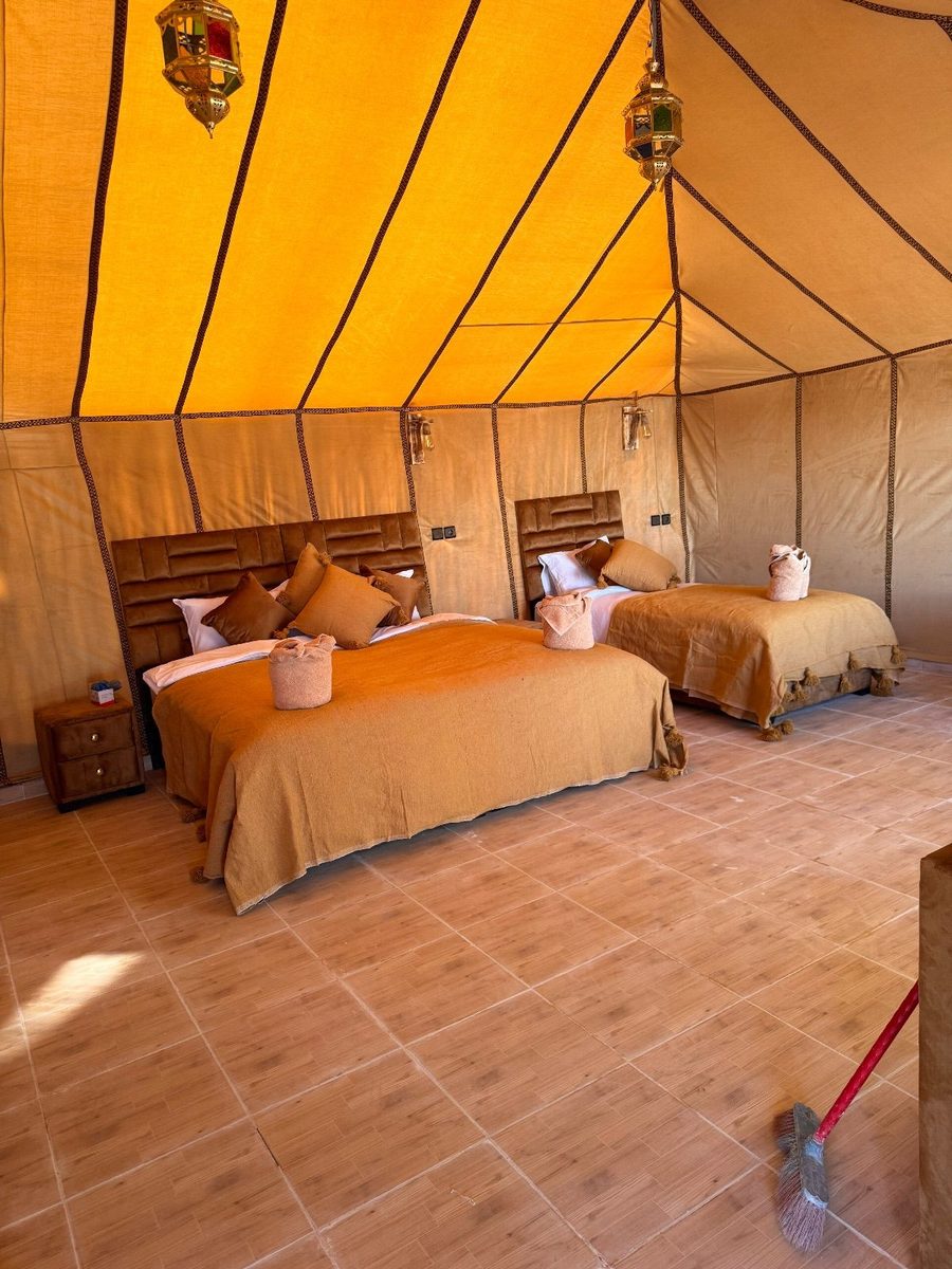 Comfortable double luxury tent interior at Grand Dune Luxury Camp with a king bed prepared for guests